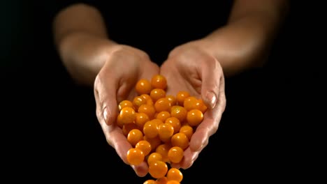 hands pouring golden berries 4k