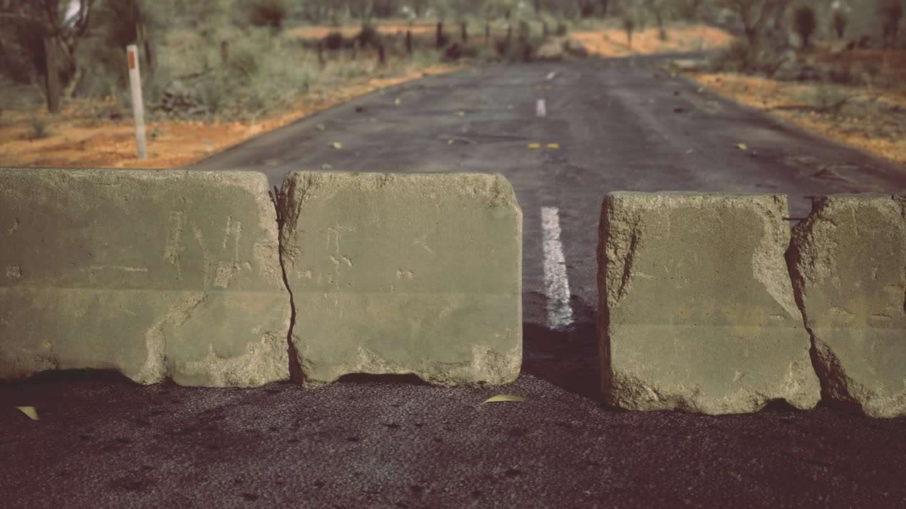 Roadblock halts travel in a remote landscape under warm sunlight