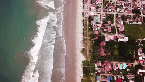 the stunning scenery of calm waters splashing into the shore in olon beach - aerial shot