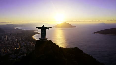 the sun rises over the ocean, casting a golden glow on christ the redeemer and the sprawling cityscape of rio de janeiro