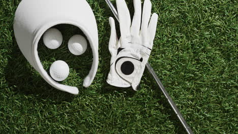 cerca del club de golf, las bolas, el guante y la gorra en la hierba, copia el espacio, la cámara lenta.