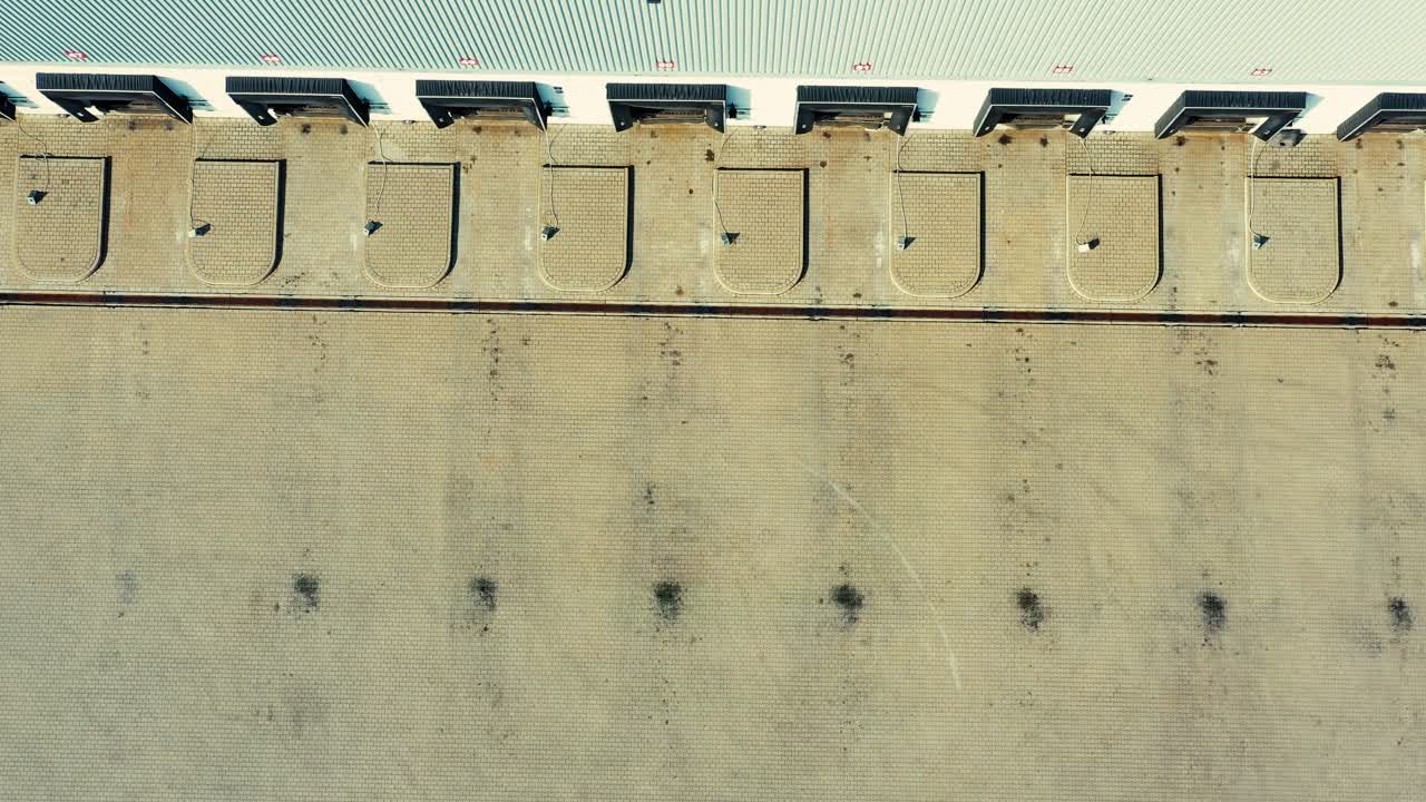 vista aérea de camiones semirremolques parados en las rampas del almacén para cargar y descargar mercancías en el parque logístico
