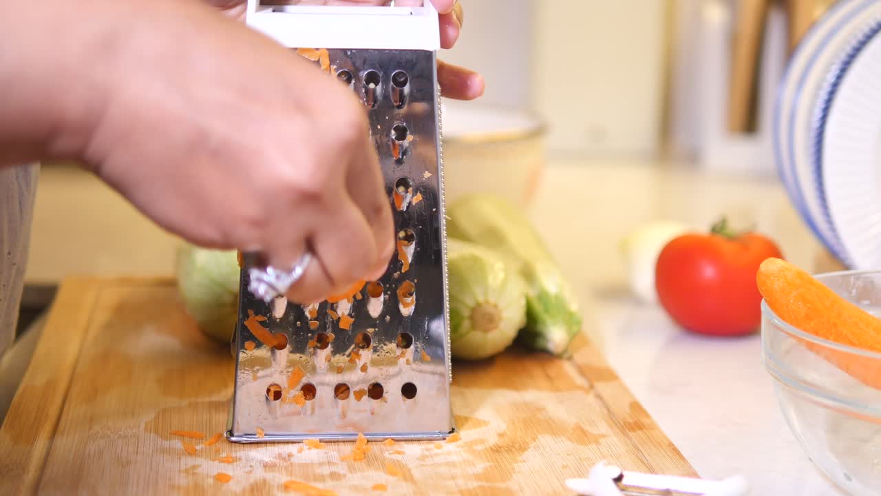 Woman grating carrots and zucchini