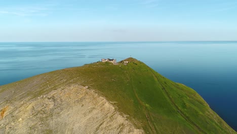 aerial view of a cape with a lighthouse and ruins