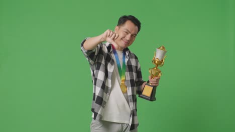 hombre sosteniendo el trofeo con expresión de decepción