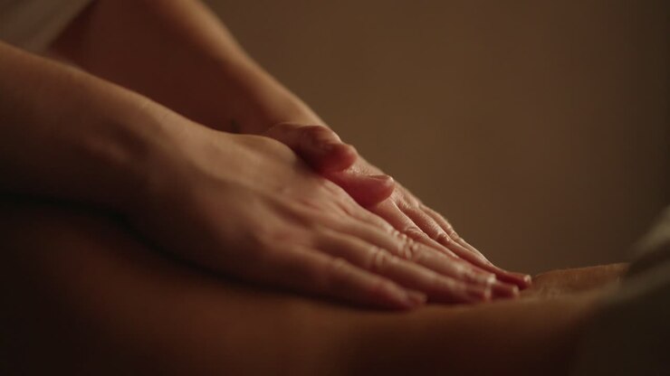 Professional Back Massage Hands in dimly lit room