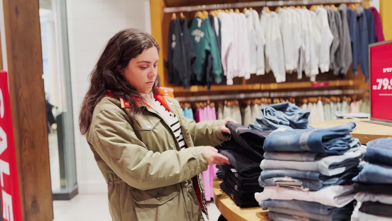Woman browsing colorful clothes in store sale section