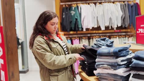 woman browsing colorful clothes in store sale section