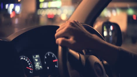 el hombre conduciendo el coche en la ciudad nocturna