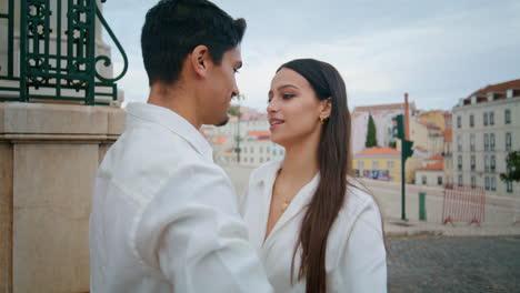 Happy-sweethearts-flirting-at-cityscape-closeup.-Latina-newlyweds-touching-noses