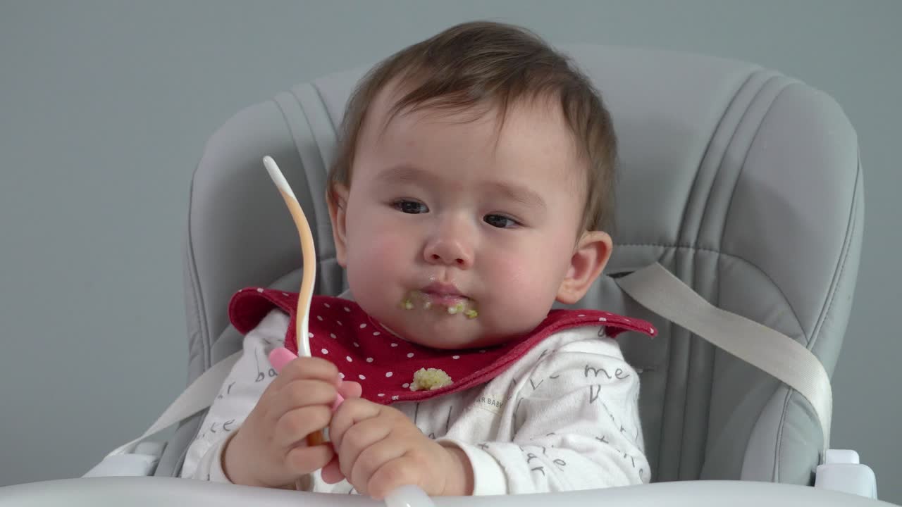 Cute Baby Eating Messy Meal in High Chair
