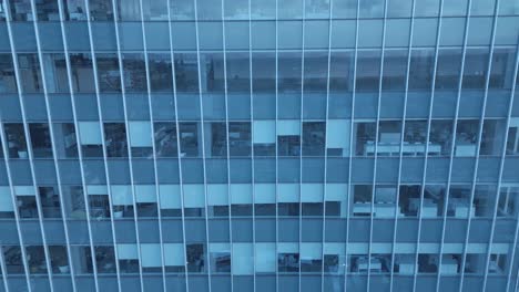 4k drone close-up empty office tower dolly roll reveal partial windows covered as quadcopter fly into the mirrored glass camera top to a direct upwards mirrored view of condo office skyscrapers