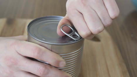 slow motion as opening a tin can with boiled corn