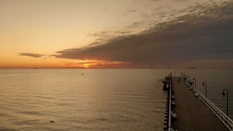 imágenes aéreas sobre el muelle e ir al mar durante el amanecer