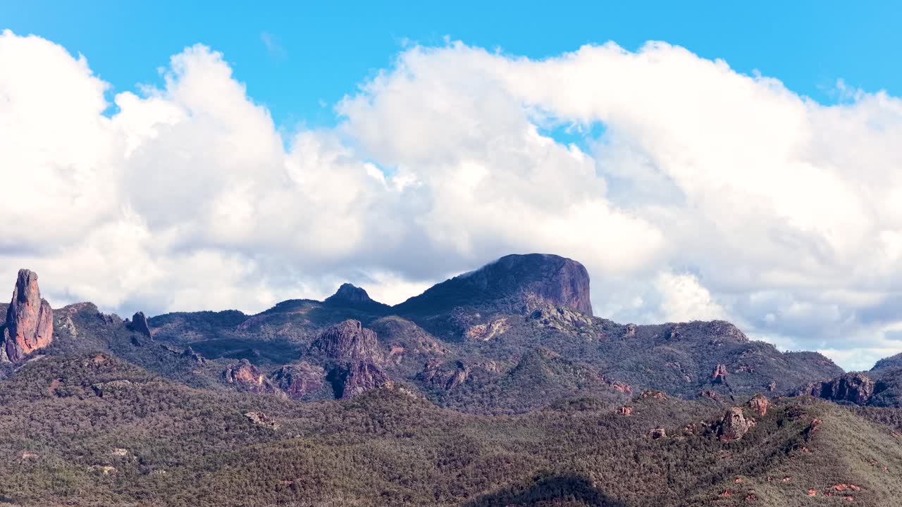 Wide daylight panorama of rugged Siding Spring mountains in Warrumbungle National Park, with slow horizontal camera pan and dramatic clouds overhead