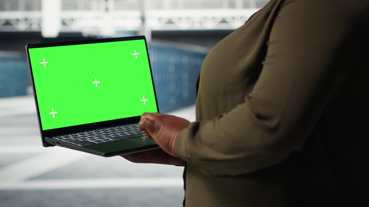 Data center expert monitors data center metrics on isolated screen laptop