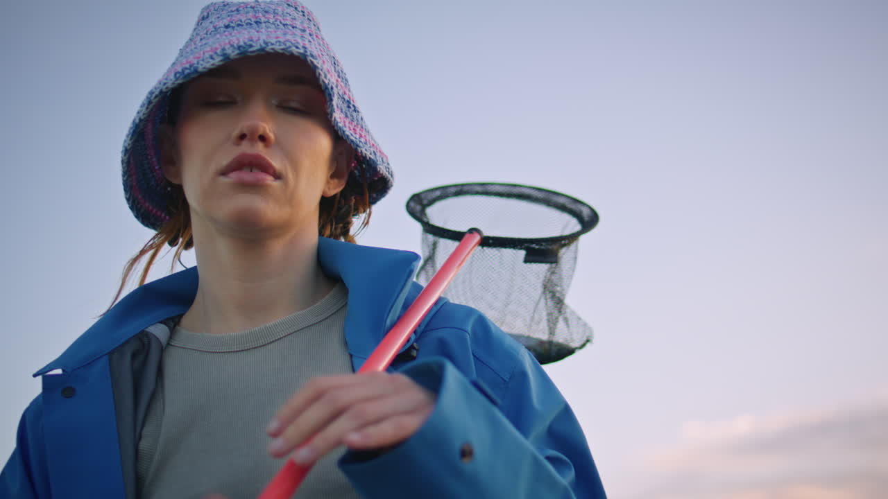 어의 하늘에서 야외에서 포즈를 취하는 모험 소녀. 심각한 여성 스쿠프를 들고