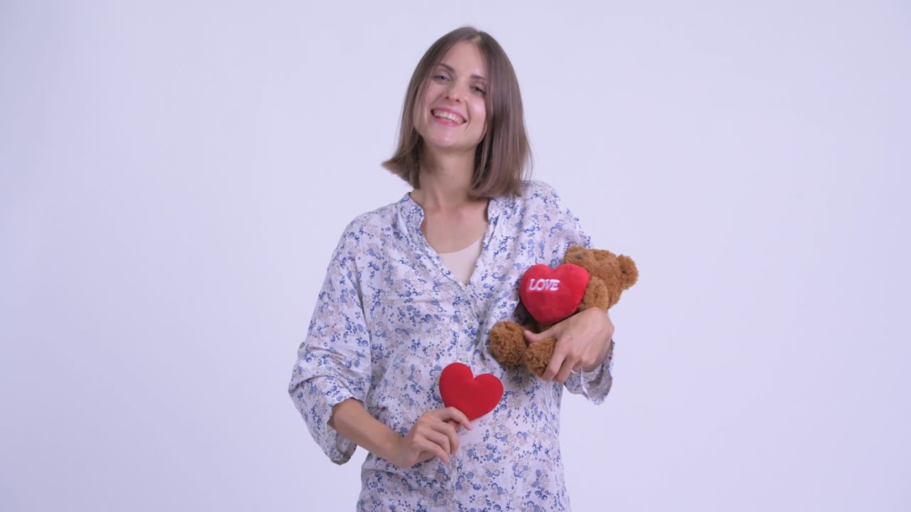 feliz joven hermosa mujer embarazada con oso de peluche