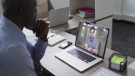 African-american-senior-man-having-a-video-call-with-male-colleague-on-laptop-at-office