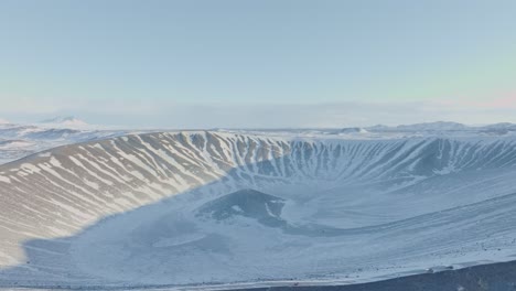 Tilt-down-reveal-aerial-shot-of-Hverfjall-volcano's-crater-in-Iceland,-region-of-Mývatn