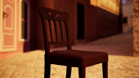 a wooden chair sits on a cobblestone street