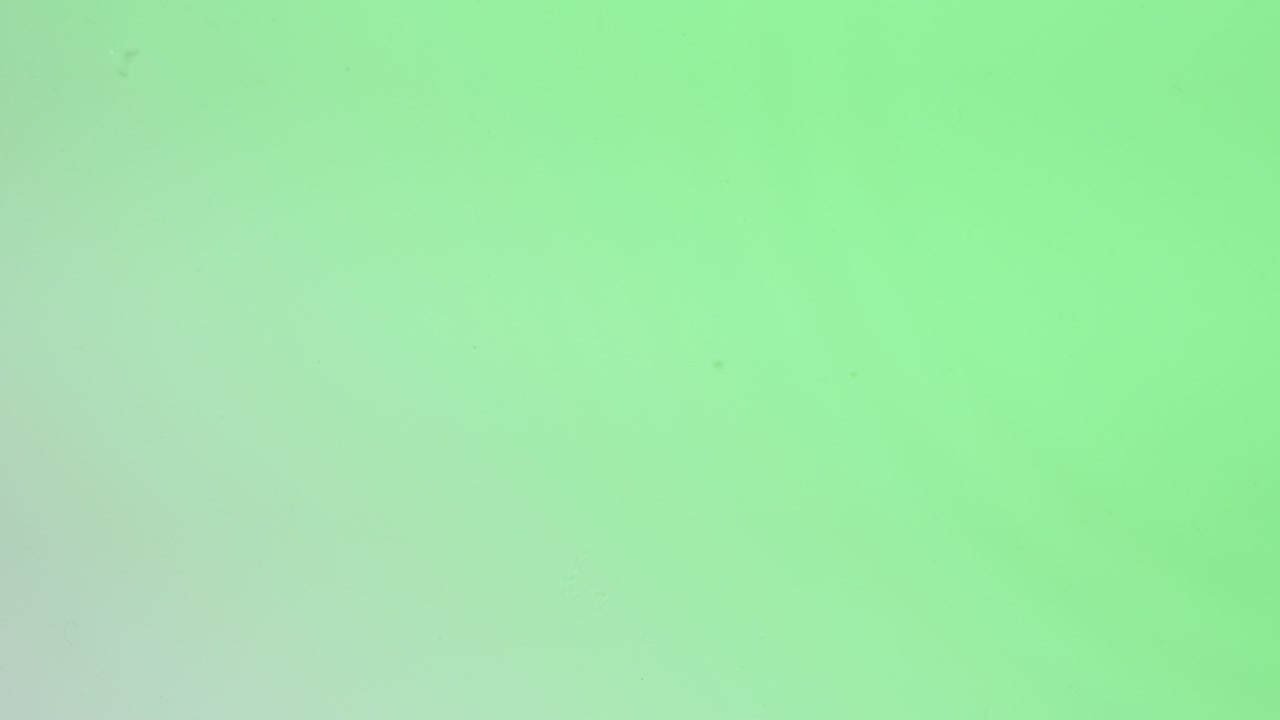 vista superior de la gota cae en el agua y círculos divergentes de agua en fondo verde