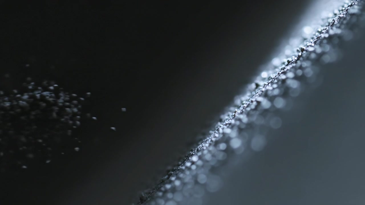 Shaking diagonal ridge coated with grains shedding from vibration in studio directional light