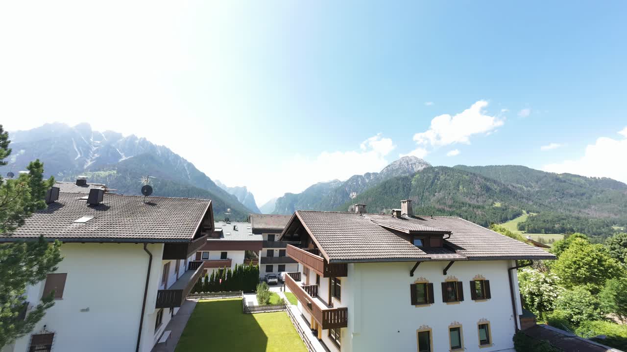 Clouds move quickly over alpine town rooftops on sunny day in scenic valley region