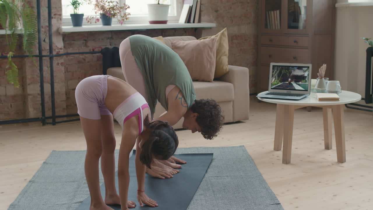 madre e hija haciendo yoga en casa