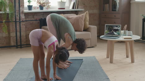 mother and daughter doing yoga at home