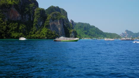 tracking shot of bright speedboat moving through deep blue sea at ko phi phi island in thailand