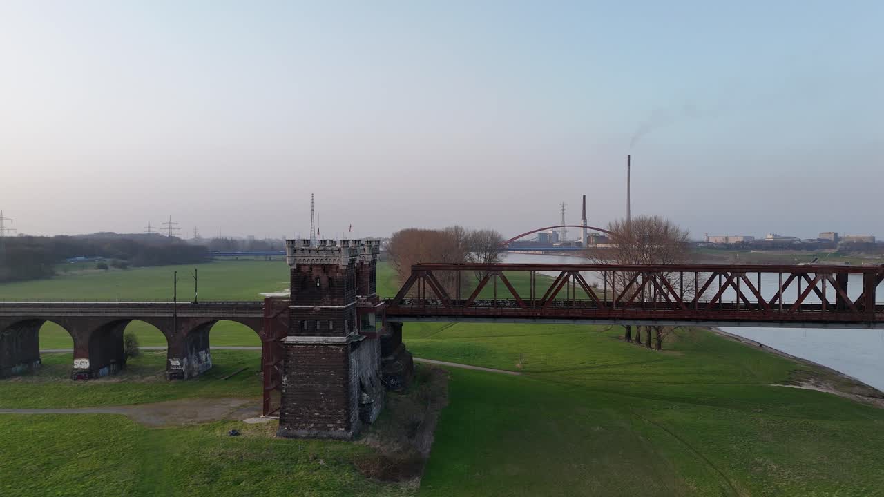 Boczny ruch drona pokazujący wieżę mostu kolejowego na rzece Ren i panoramę Duisburga ze Stadtwerketurm.