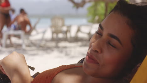 Latino-Lady-Relaxing-in-Shade-on-Beach-Looking-at-Camera-with-Alluring-Seductive-Expression-on-her-Face,-closeup