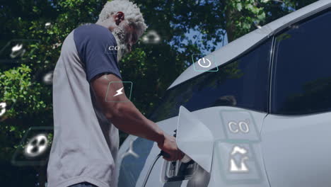 animación de iconos ecológicos sobre un hombre biracial cargando un coche eléctrico