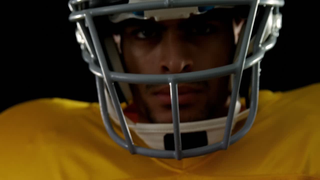 Giocatore di football americano che tiene il pallone con entrambe le mani 4k