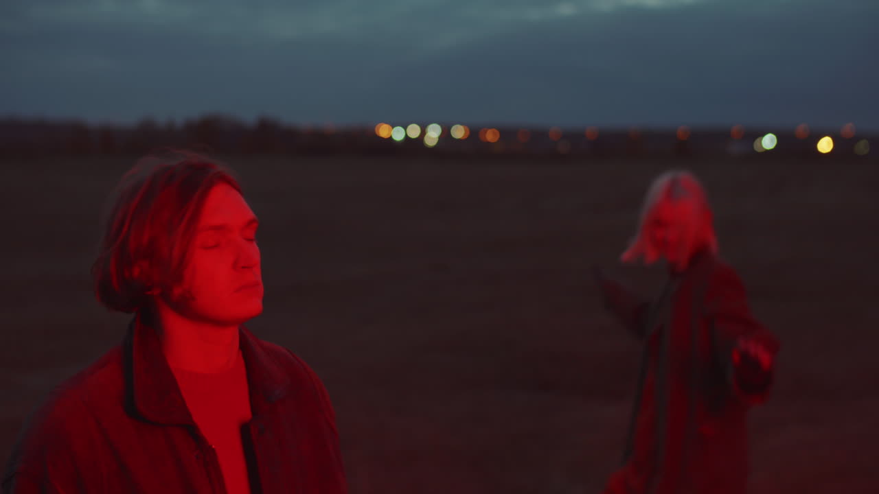 мужчина наслаждается музыкой и женщина танцует на открытом воздухе