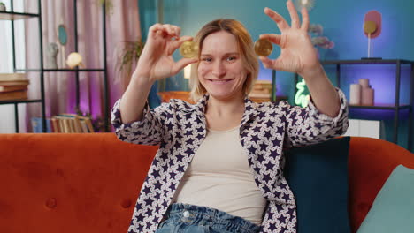 woman holding two bitcoin coins over her eyes