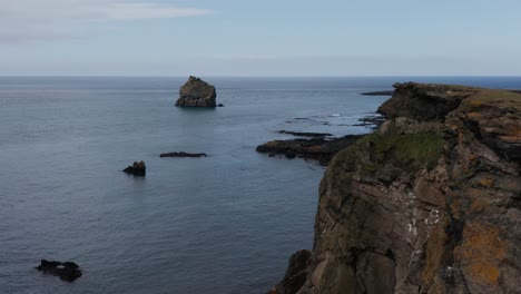 Dark-basalt-cliffs-at-shore-of-Iceland-Valahnúkamöl-area,-aerial