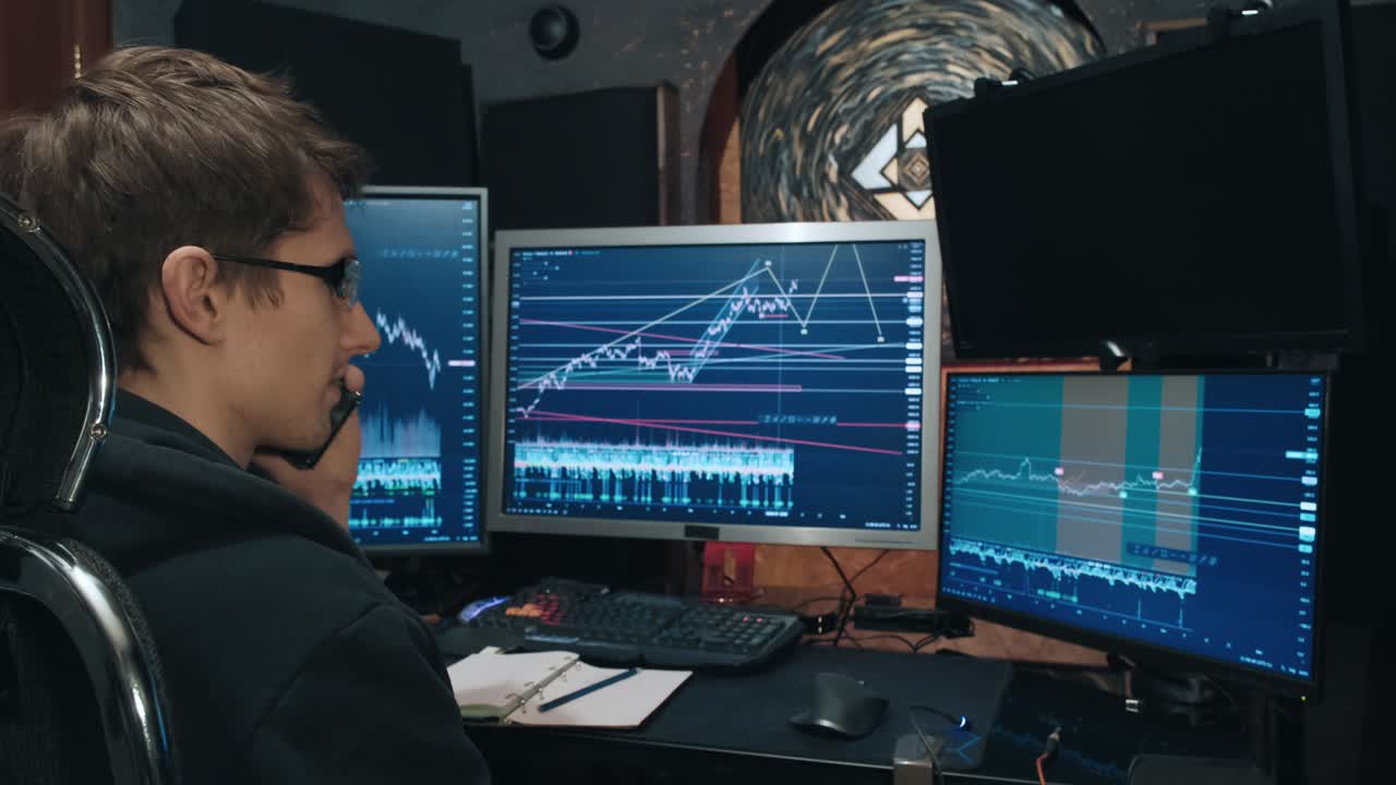 comerciante masculino, un independiente discute las listas de cotización de la bolsa de valores por teléfono