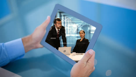 un hombre de negocios con una tableta mostrando un video de personas ocupadas.