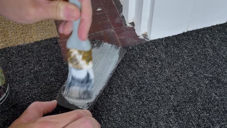 Using-brush-to-apply-glue-to-carpet-for-fitting