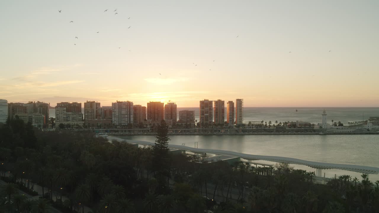 Vista aérea mostrando a silhueta de edifícios altos durante um belo pôr do sol ao fundo