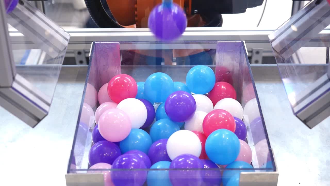 robot colocando bolas de colores en un recipiente