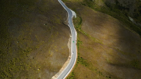 Overtaking-on-Mountain-Road-to-Wanaka-from-Queenstown-in-New-Zealand,-aerial-drone-view