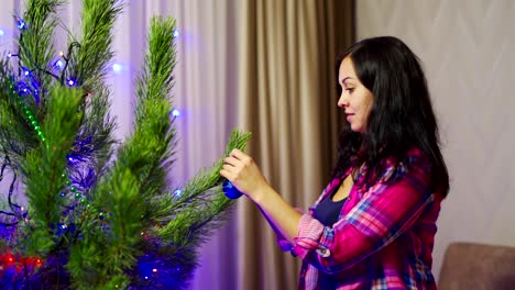 woman decorating christmas tree. elegant woman decorating the christmas tree