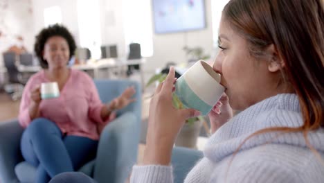 Diverse-business-female-colleagues-drinking-coffee-and-talking-in-office,-slow-motion