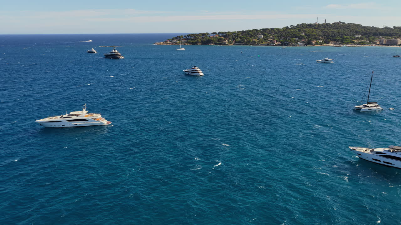 Vista aerea da drone di yacht di lusso e barche a vela ancorati nelle acque blu del Mar Mediterraneo al largo della costa di Antibes