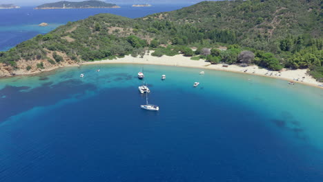 Aerial:-Sailboats-and-catamarans-on-Tsougria-island-beach-near-Skiathos,-Sporades,-Greece