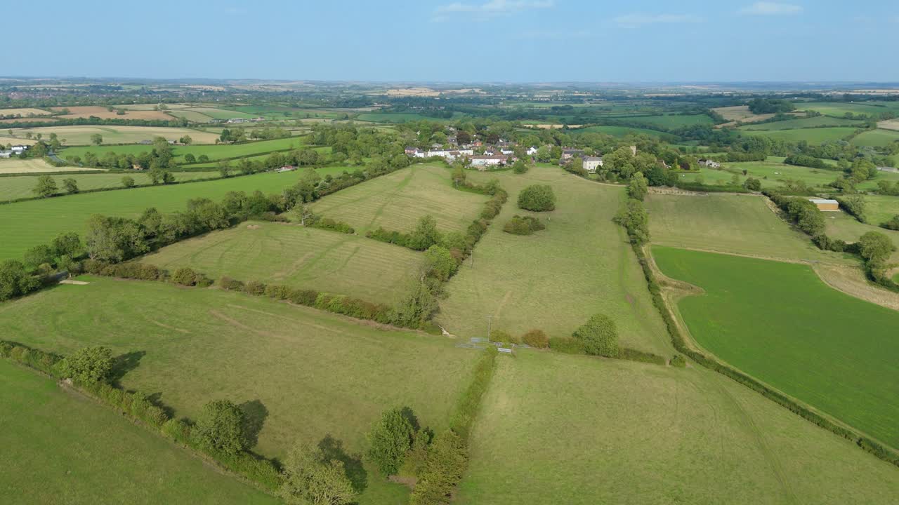Aerial drone view of small village and surrounding green rural landscape in England UK on a sunny summer day