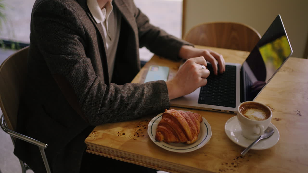 hombre trabajando en su computadora portátil en un café